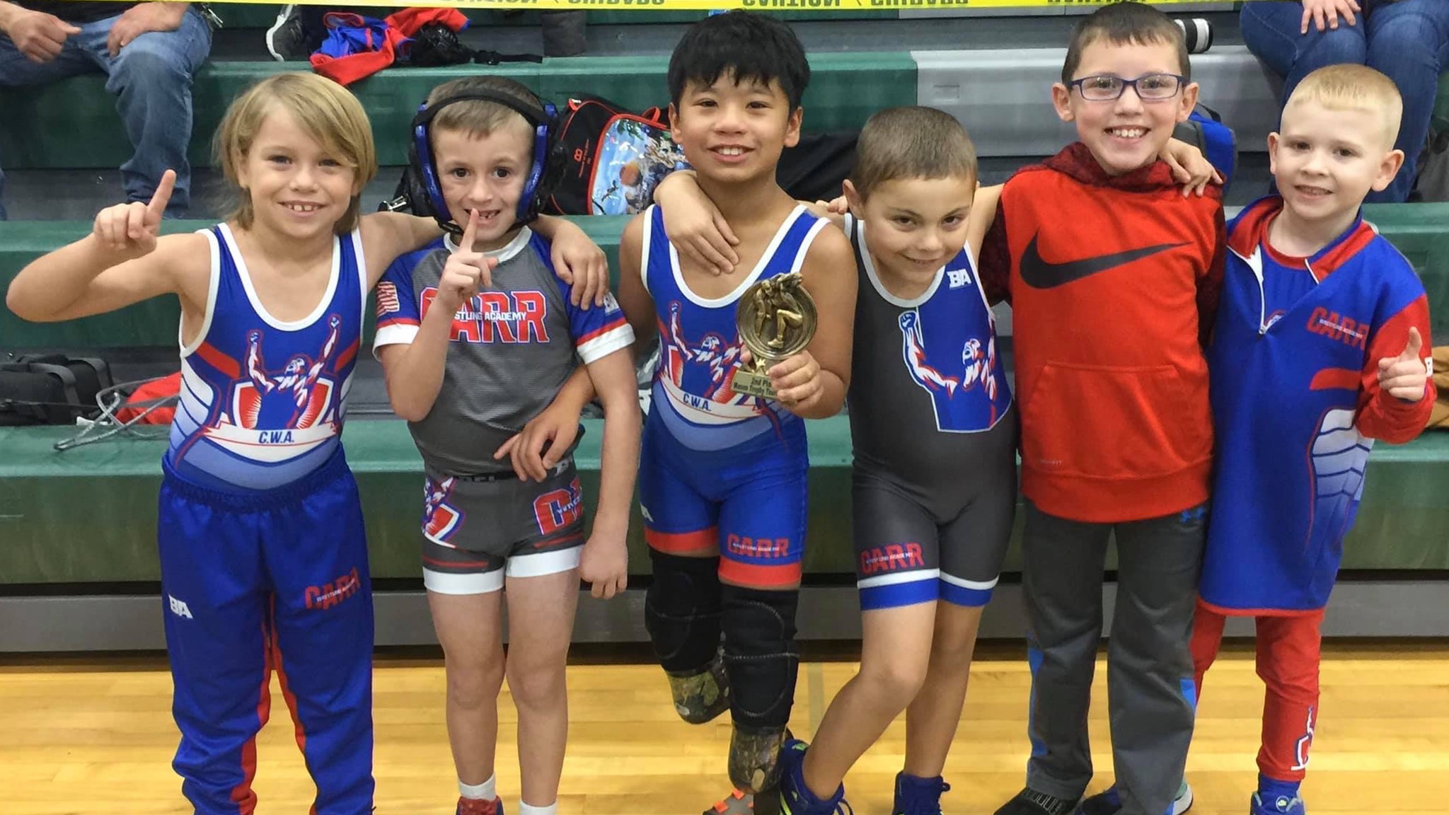 a group of kids posing for a picture with their trophies.