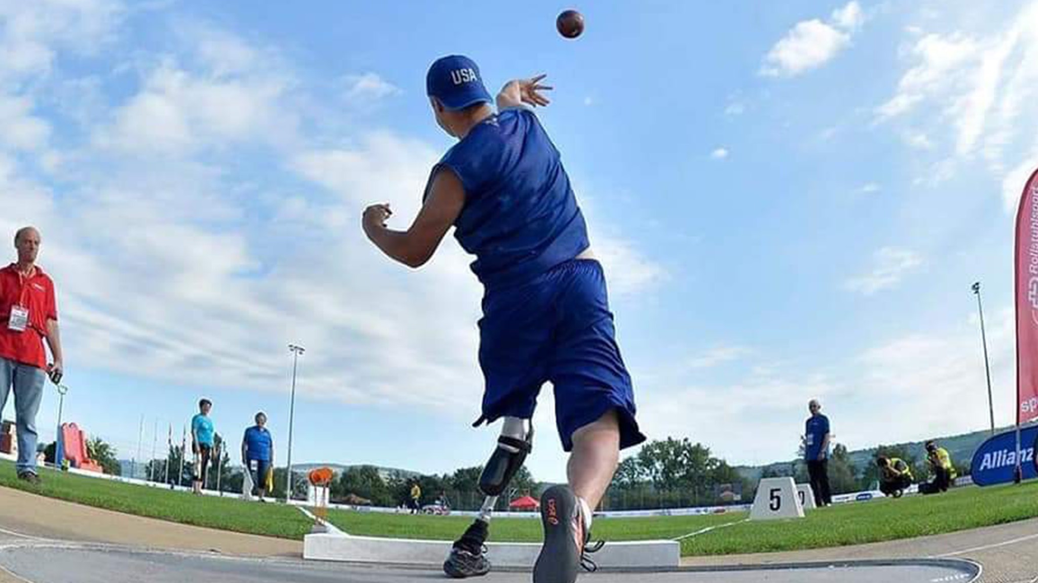 a man throwing a ball at a competition.