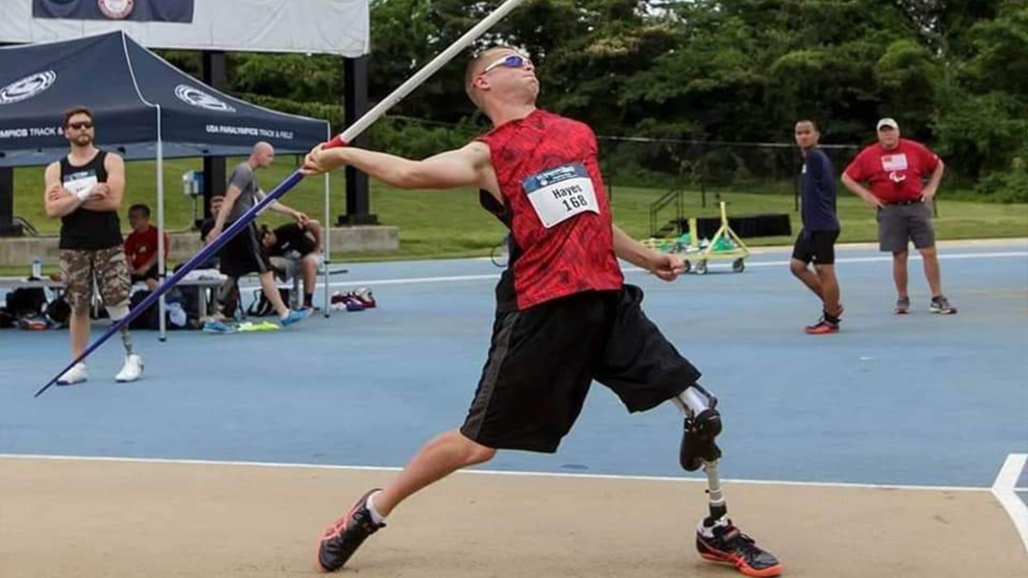 a man with a prosthetic leg is throwing a javelin.