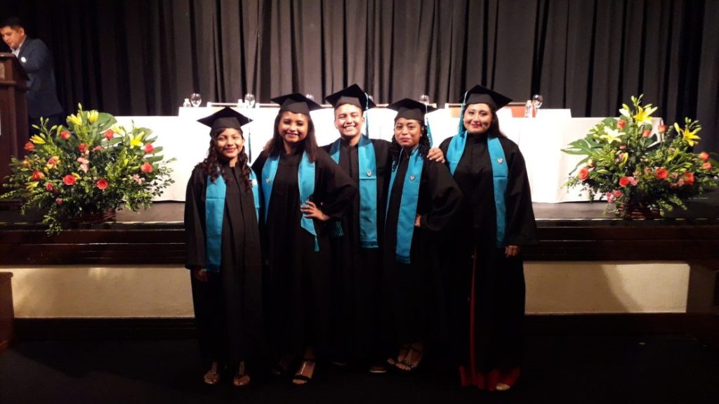 a group of women in graduation gowns posing for a photo.