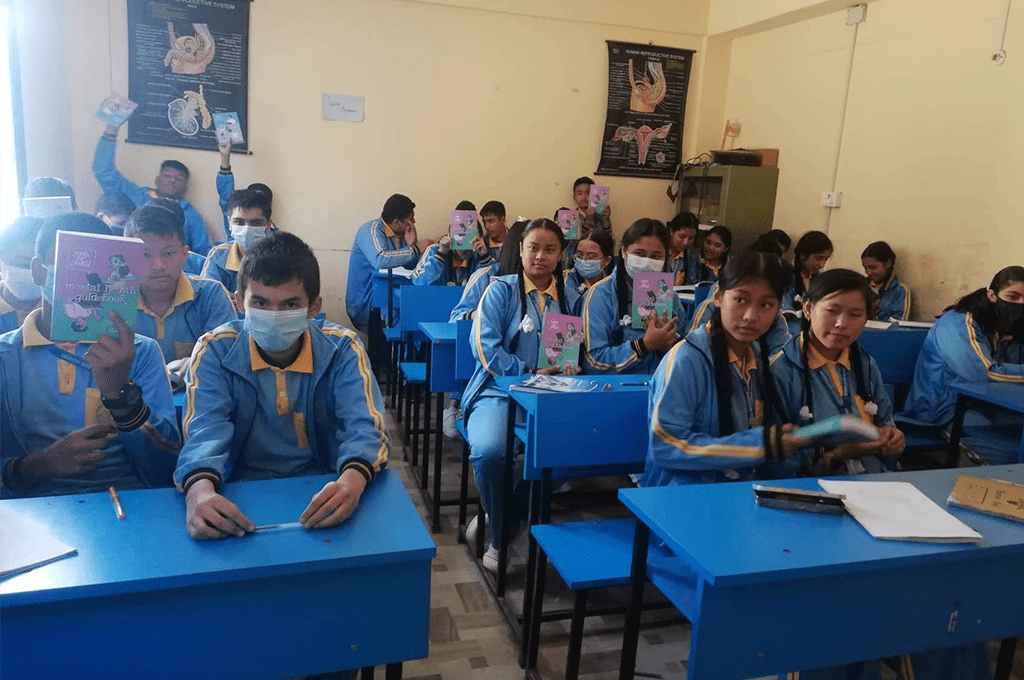 a group of students in blue uniforms in a classroom.