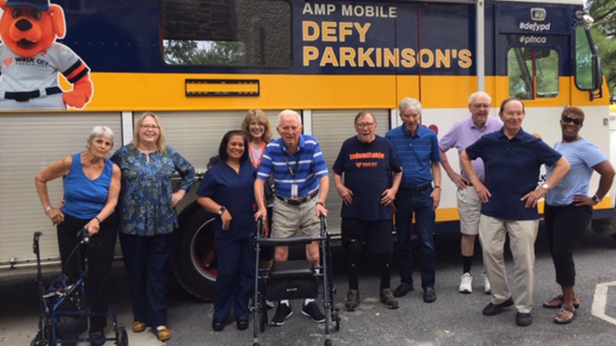 a group of people posing for a photo in front of a bus.