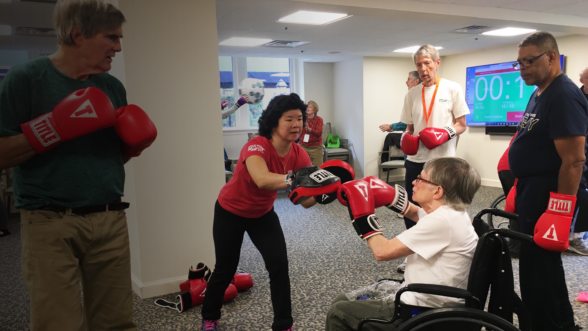 a group of people in a room with boxing gloves.