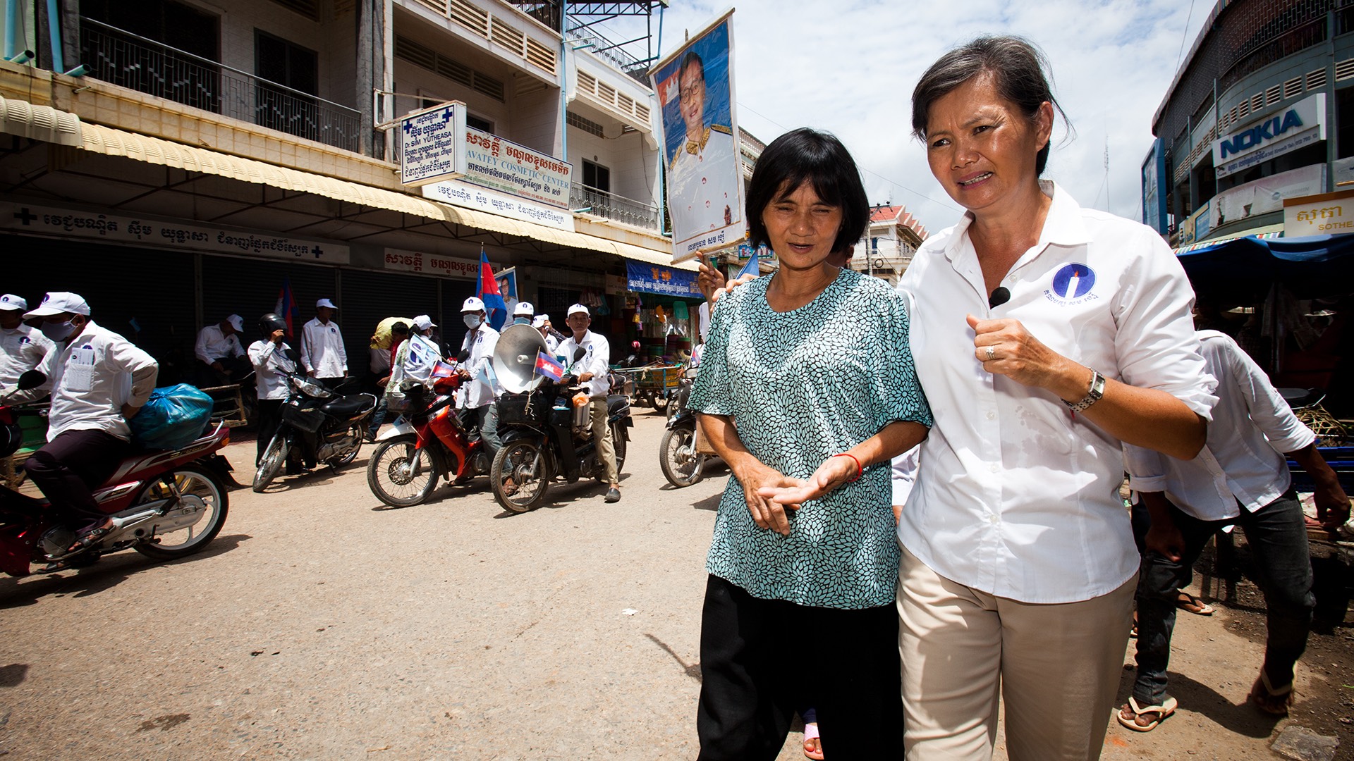 two women walking down a street in cambodia.