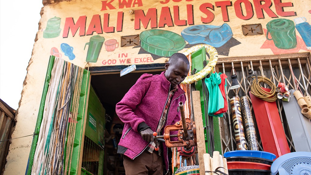 a man standing in front of a store with a sign on it.