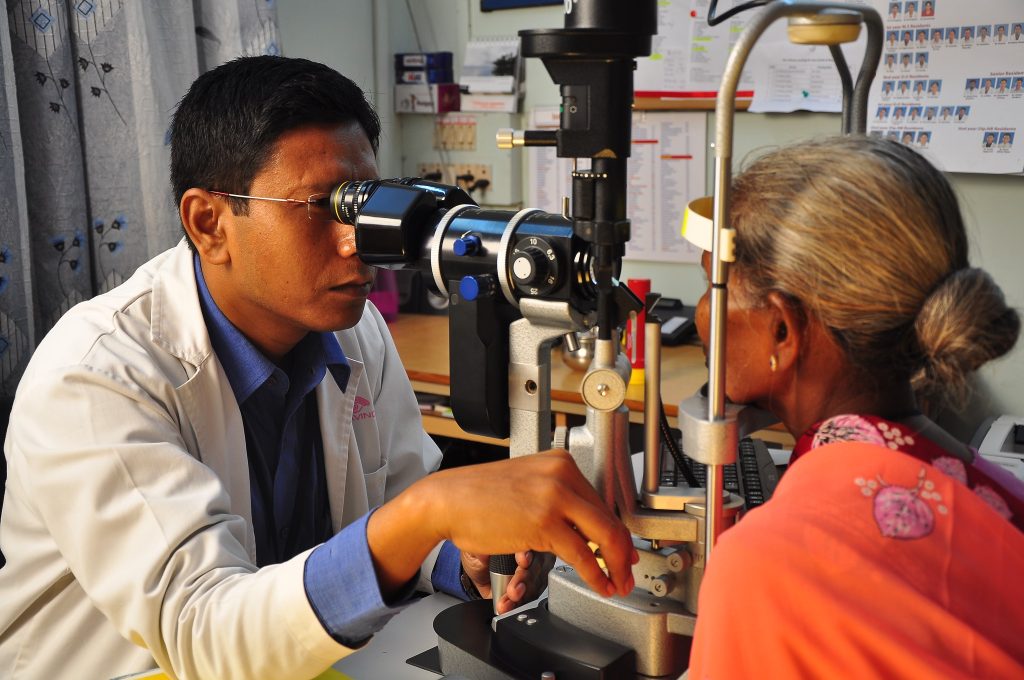 an elderly woman is being examined by an eye doctor.