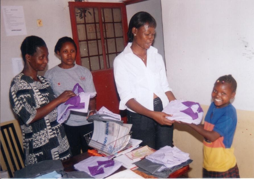 a group of women and children standing around a table.