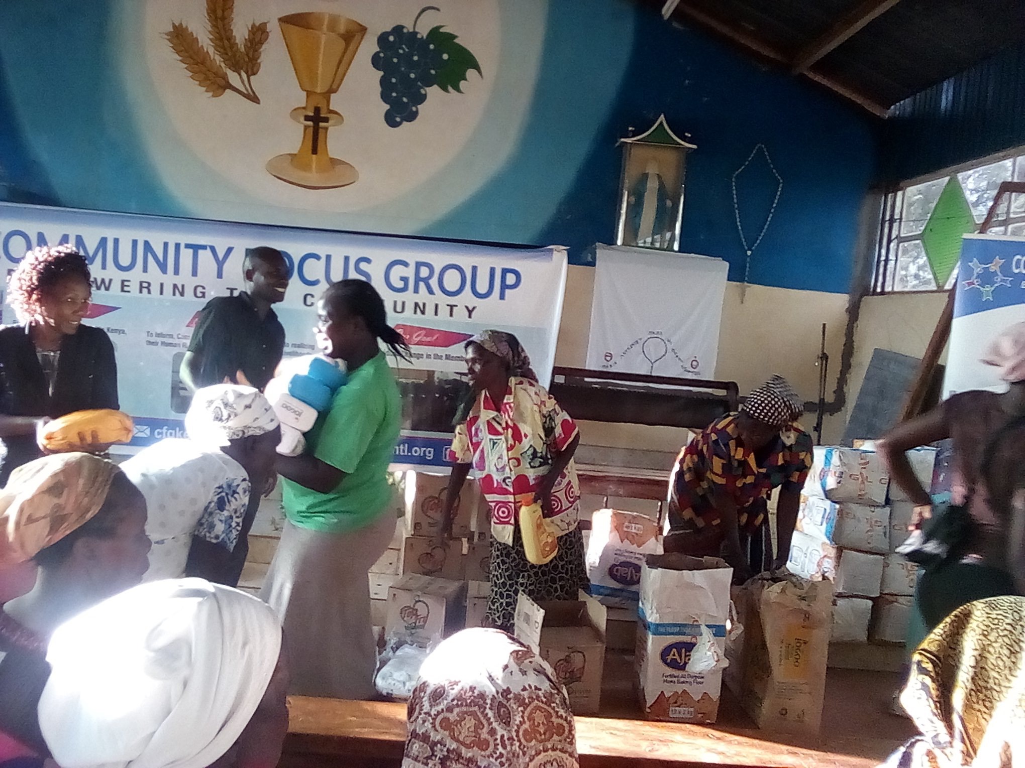 a group of people standing in a church with bags of food.