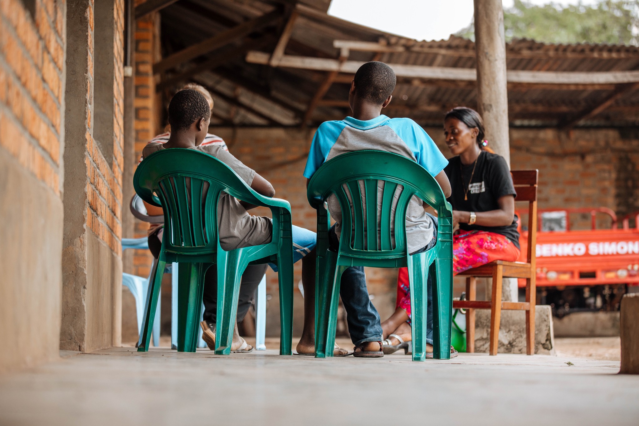 a group of people sitting on chairs in front of a building.