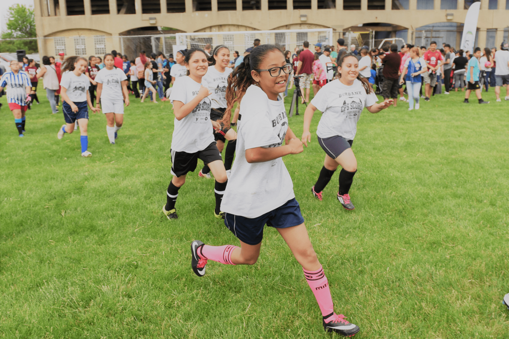 Middle school girls soccer team running on the pitch