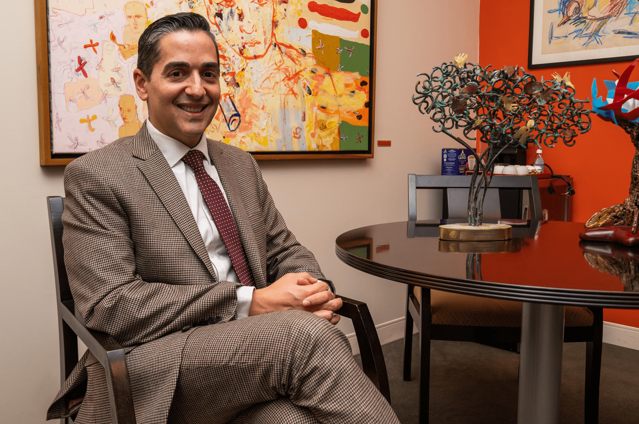 a man in a suit sitting in a chair.