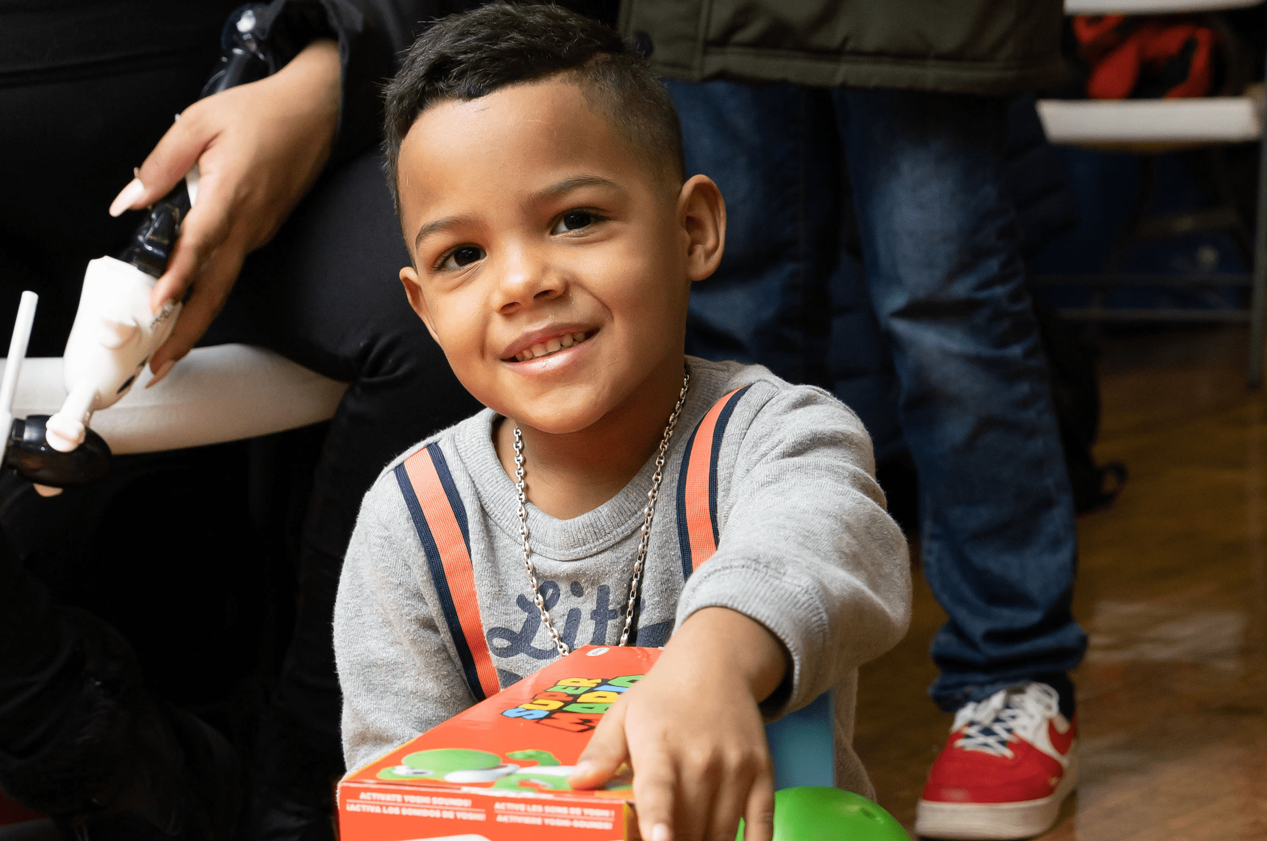 a young boy holding a box of toys.