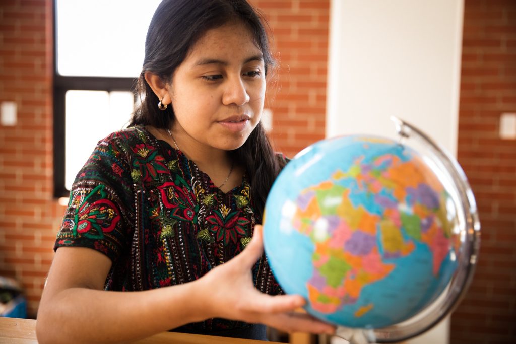 a girl is holding a globe.