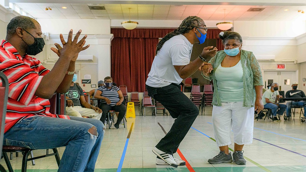 a group of people are dancing in a room with masks on.