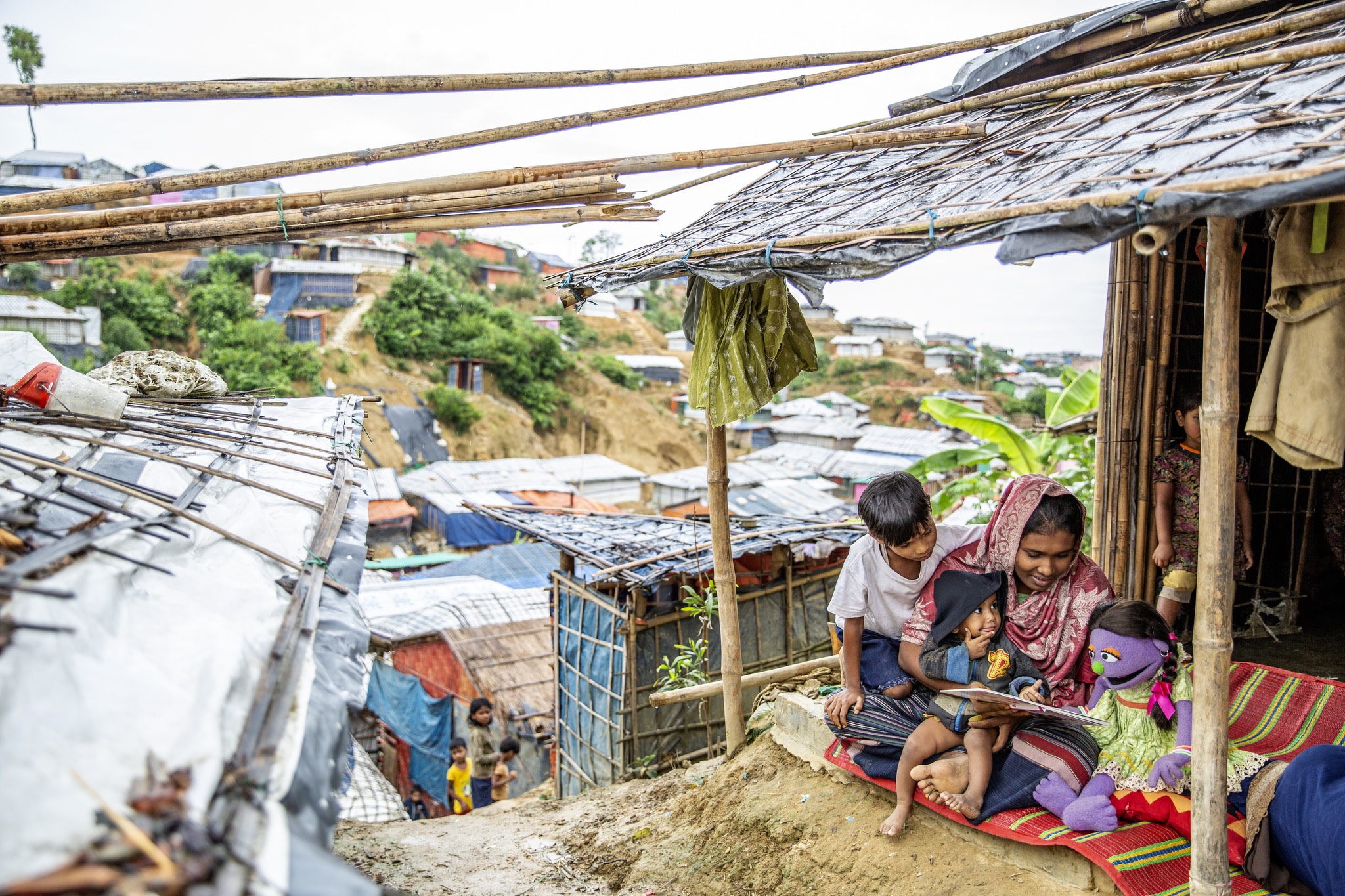 a group of people sitting in a shack on a hillside.