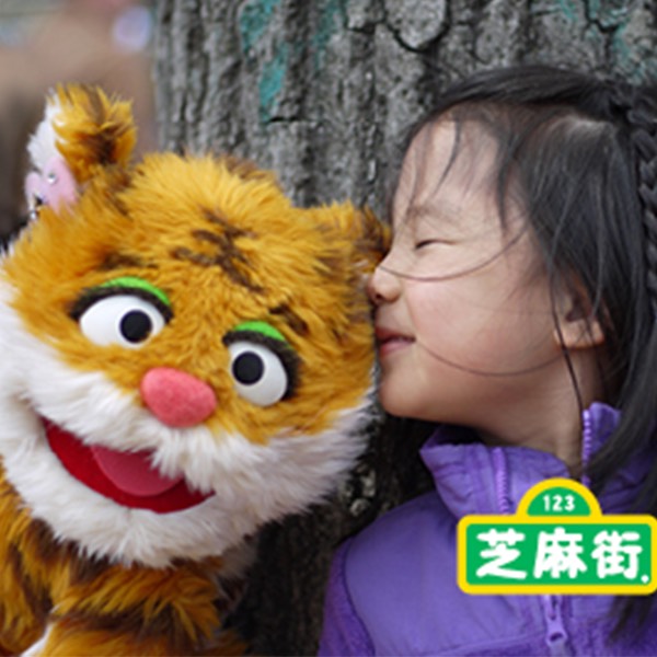 a little girl kisses a stuffed tiger.