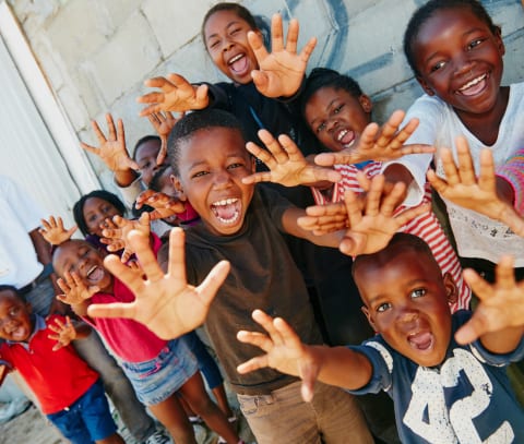 a group of children with their hands up in the air.