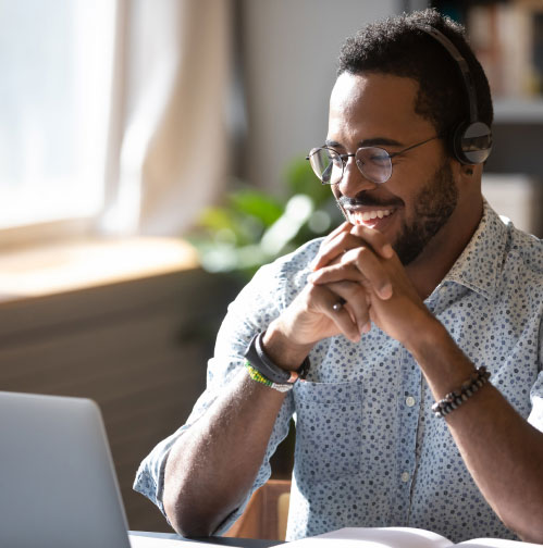 a man wearing a headset while working on a laptop.