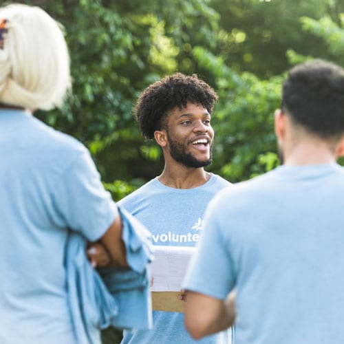 Group of volunteers engaging in a discussion outdoors.